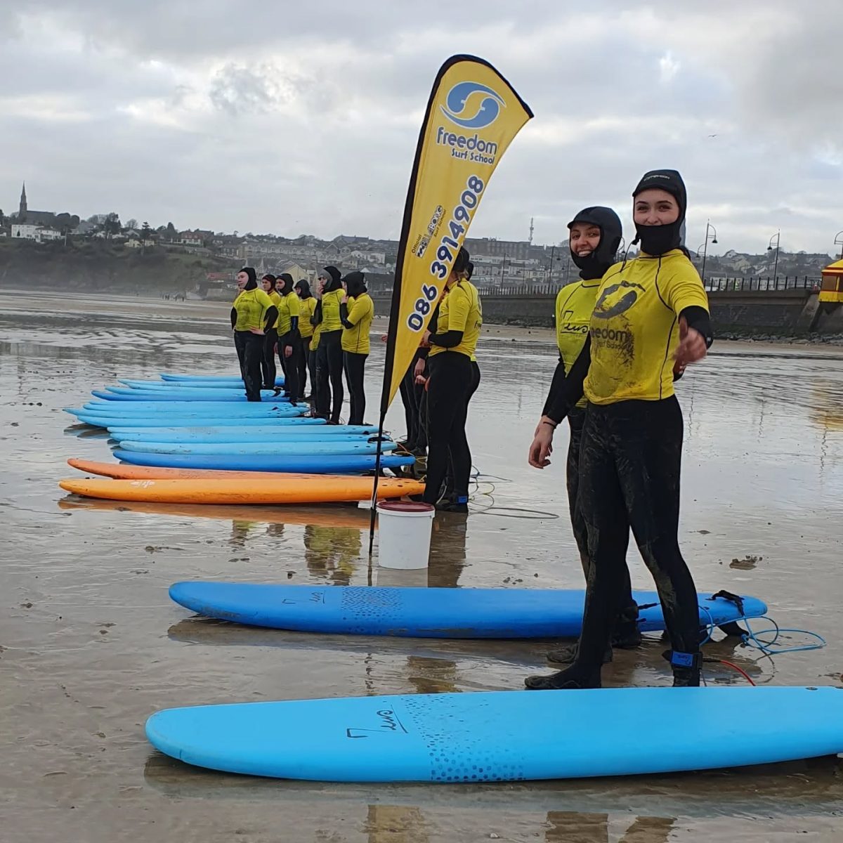 Surfers taking a lesson with Freedom Surf School on Tramore Beach in County Waterford