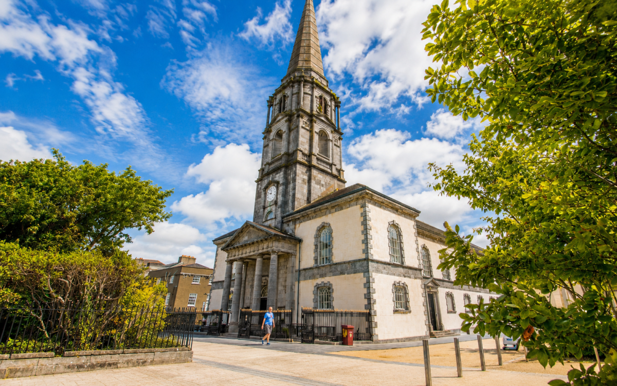 Christ Church Cathedral in Waterford City, framed by trees under a blue sky in the historic Viking Triangle.