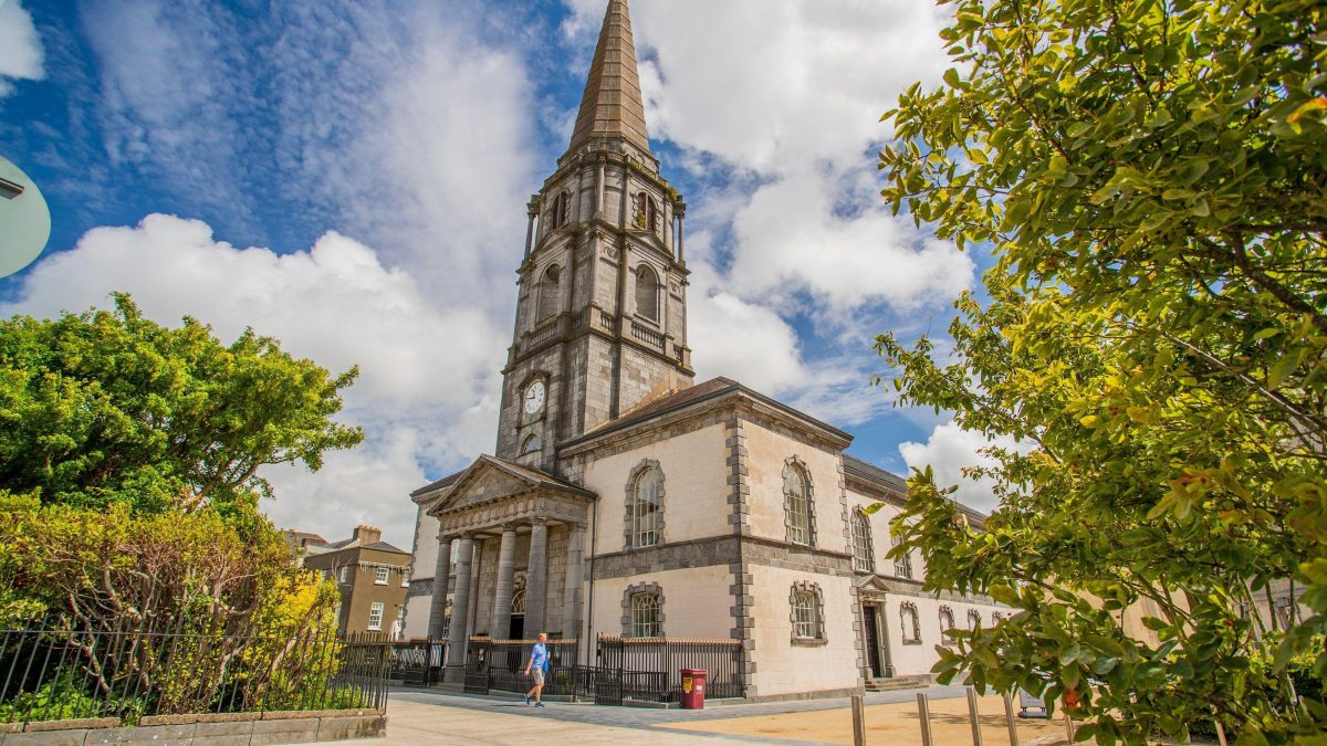Christ Church Cathedral in Waterford City, framed by trees under a blue sky in the historic Viking Triangle.